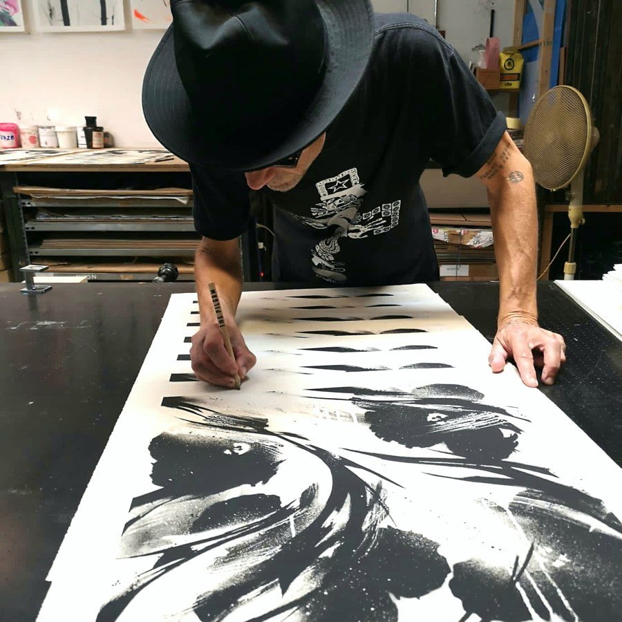 SheOne signing his BLCKFLWRS prints
